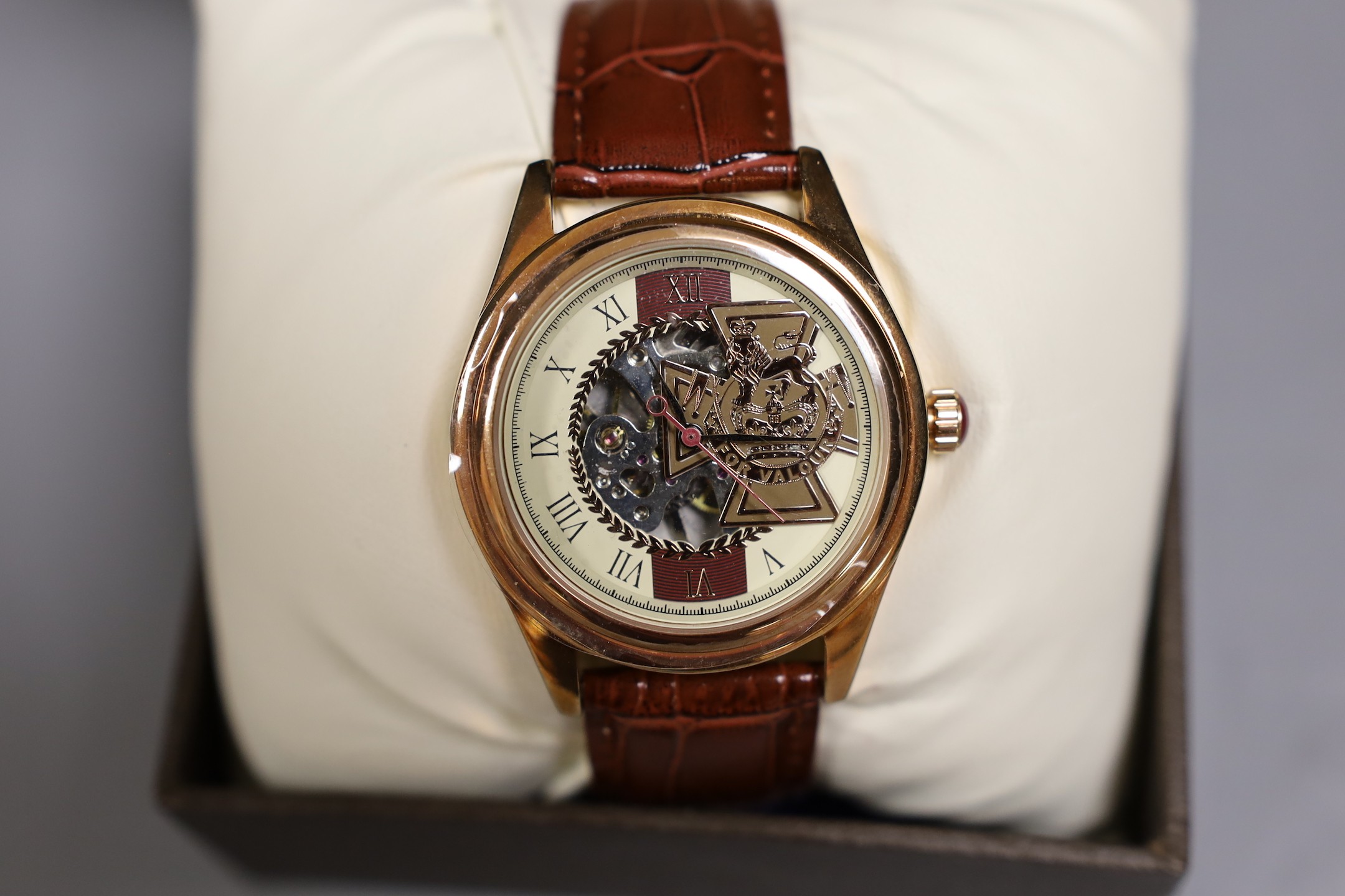 A circular plated carriage clock with key and a Victoria Cross gent's wristwatch
